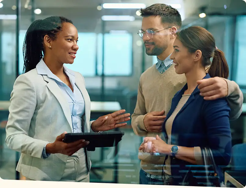 A real estate agent has a discussion with a happy couple.